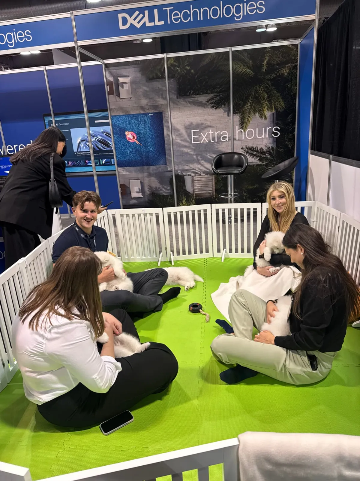 Guests sitting with Samoyed puppies at the Dell Technologies booth