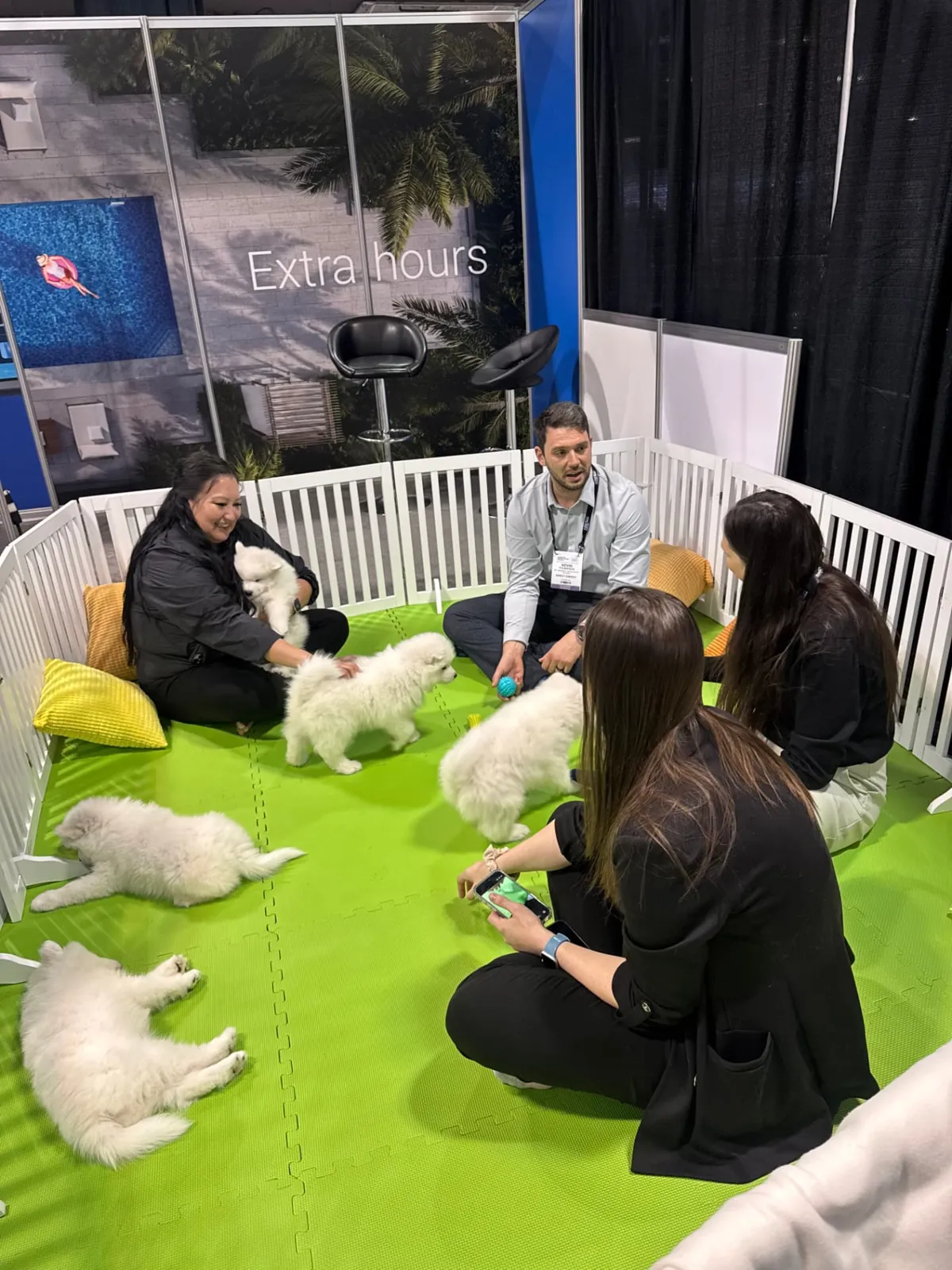 Attendees playing with Samoyed puppies at the Dell Technologies booth