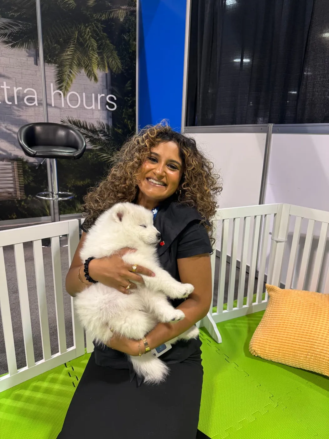 Smiling attendee holding a sleepy puppy at a brand activation