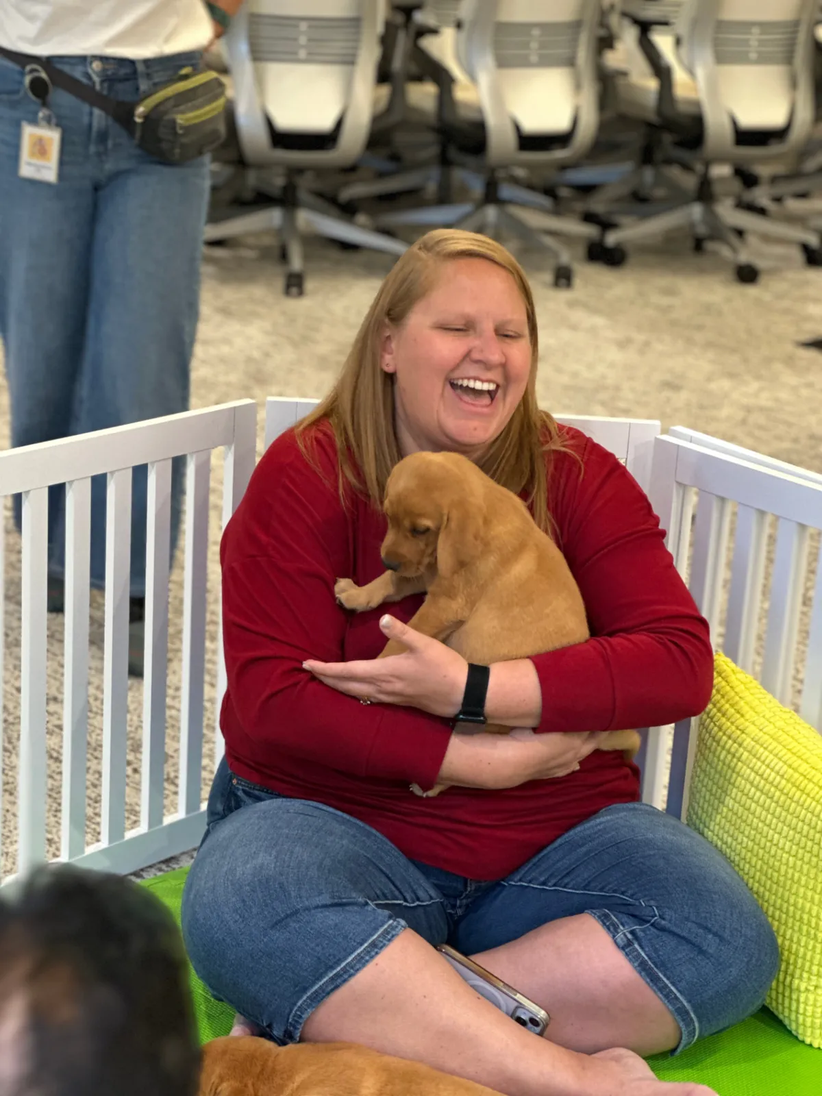 Guest laughing while cuddling a puppy